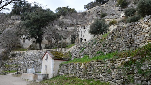 Charming stone buildings and walls in the peaceful landscape of Bollène, France.