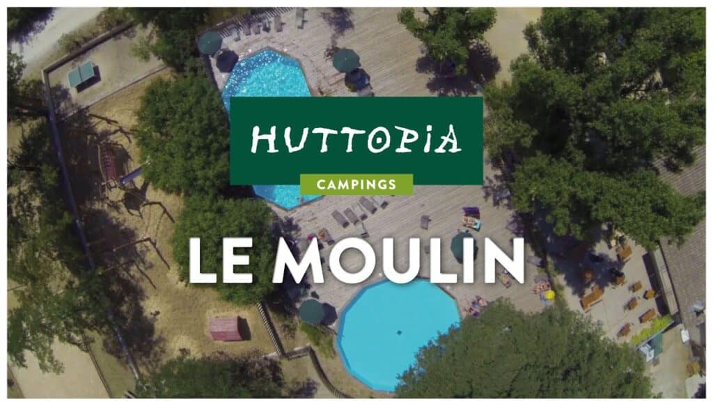 Vue aérienne du Huttopia Campings Le Moulin. Deux piscines, terrasse en bois, transats et aire de jeux sous les arbres.