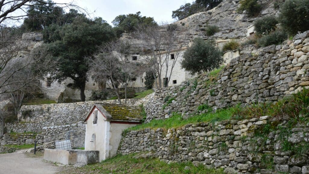 Charming stone buildings and walls in the peaceful landscape of Bollène, France.